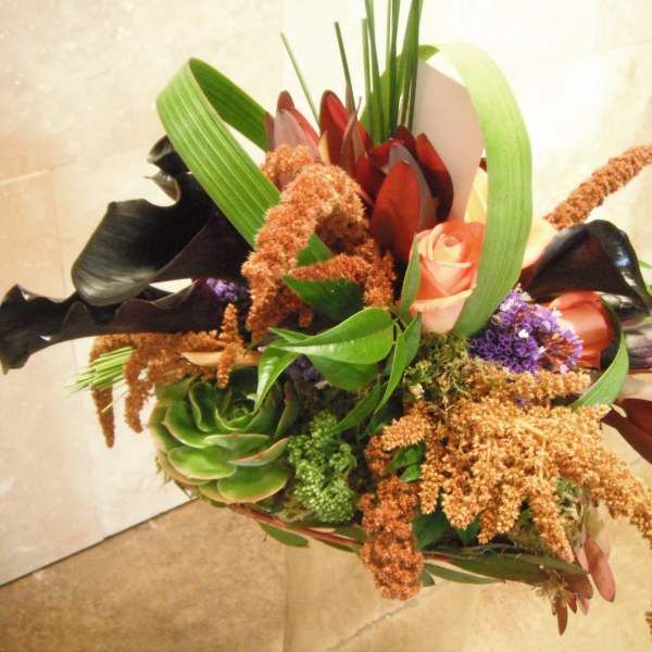 Bouquet with pink roses, black calla lilies, and green succulent accents