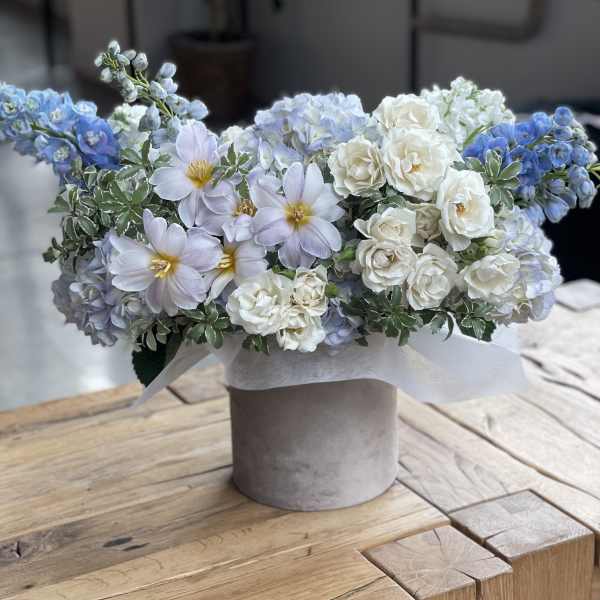 Blue and white floral arrangement in a gray vase