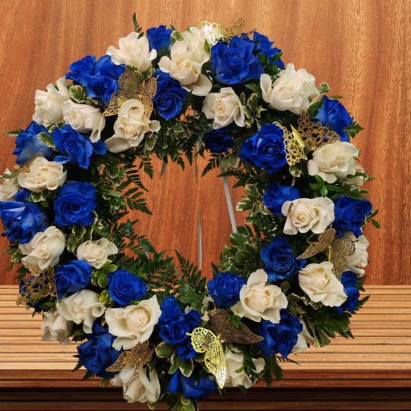 Circular wreath of blue and white roses with gold butterfly accents