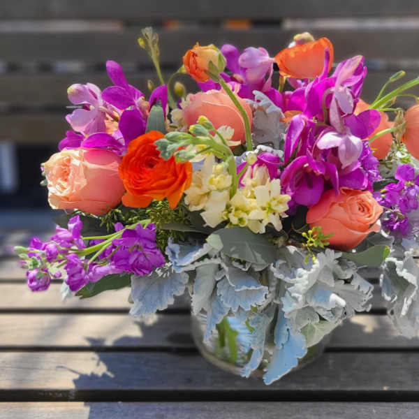 Bouquet of orange, pink, and purple flowers in a glass vase