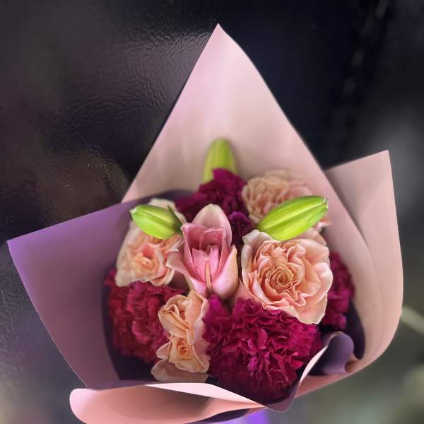 Pink and peach bouquet with lilies and carnations wrapped in pastel paper