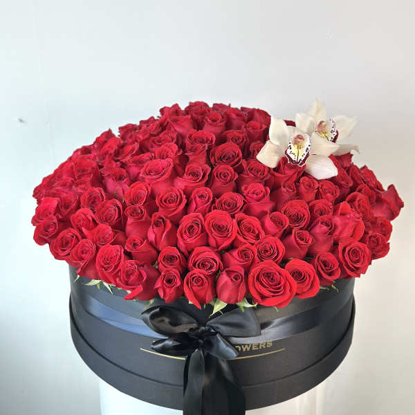 Large box of red roses with white orchids and a black ribbon