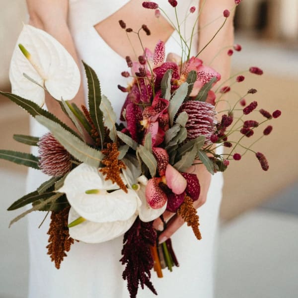 Bride holding a bouquet of white anthuriums and pink orchids