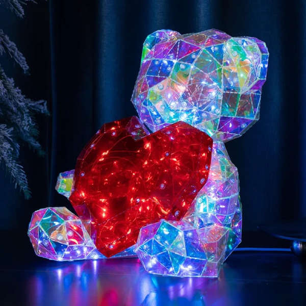 Colorful illuminated teddy bear sculpture with a red heart