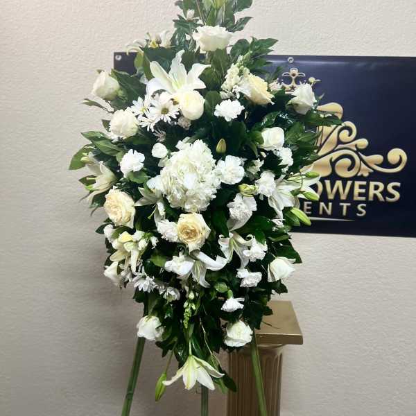 White floral standing spray with lilies and roses on an easel