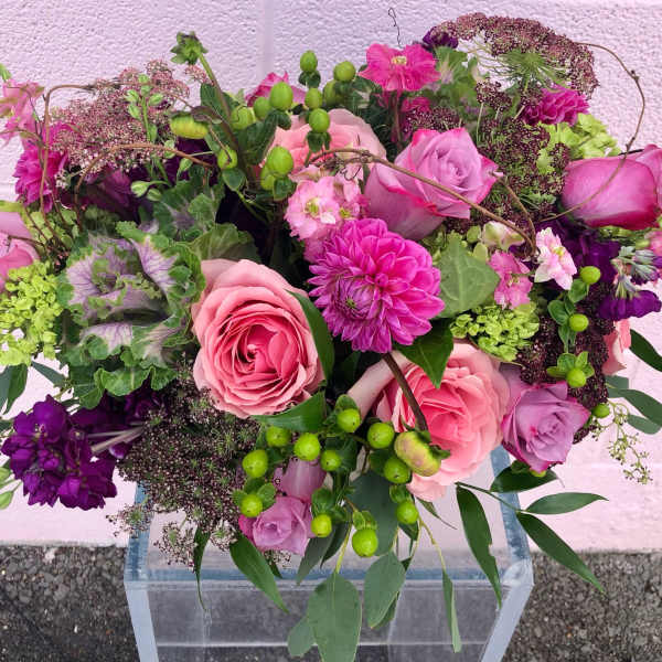 Pink and purple mixed bouquet with roses in a clear vase