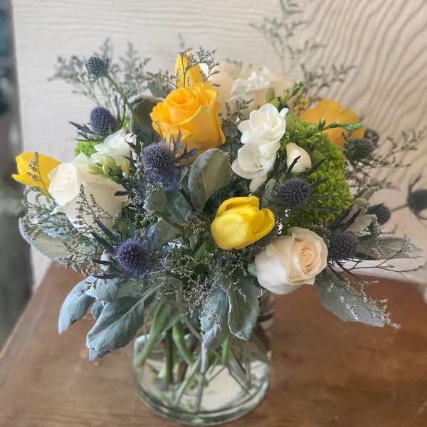 Bouquet of yellow and white roses in a clear glass vase