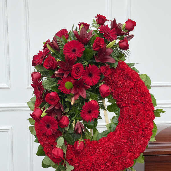 Red floral funeral wreath on a standing easel