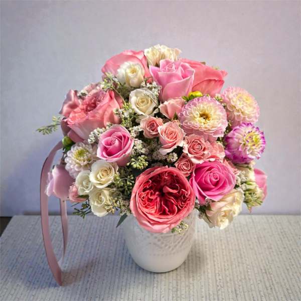 Pink and white rose bouquet in a white vase