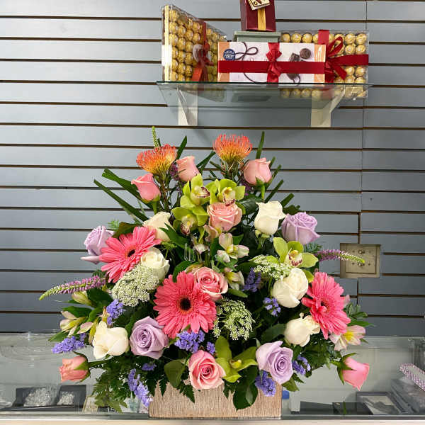 Mixed bouquet with pink, white, and lavender flowers in a rectangular container