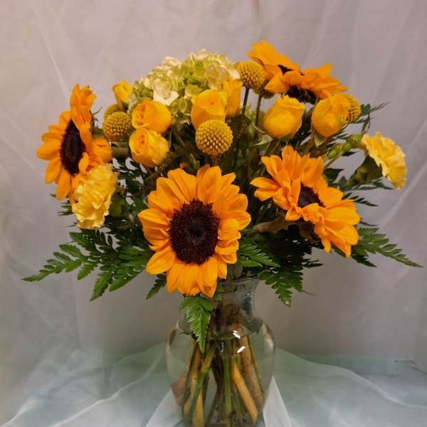 Sunflowers and yellow roses in a glass vase
