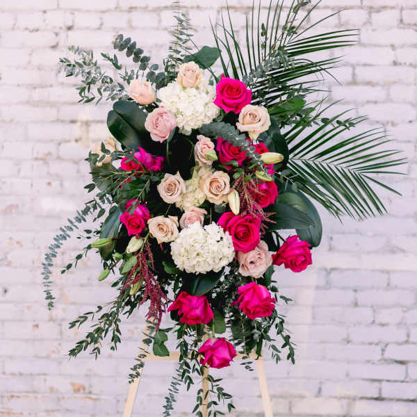 Tall floral spray with pink and cream roses on an easel