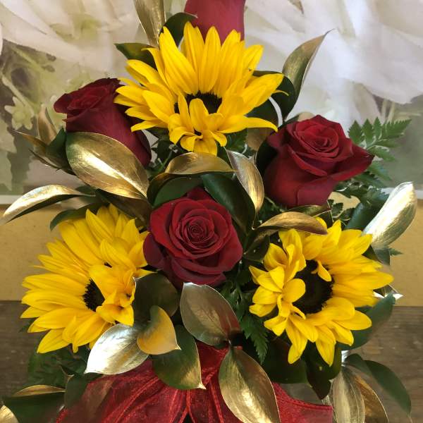 Bouquet of red roses and yellow sunflowers with a red ribbon