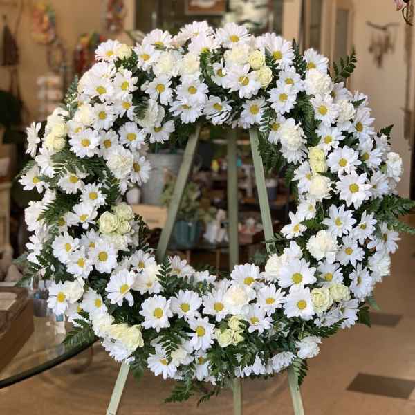 White daisy and rose wreath on a stand