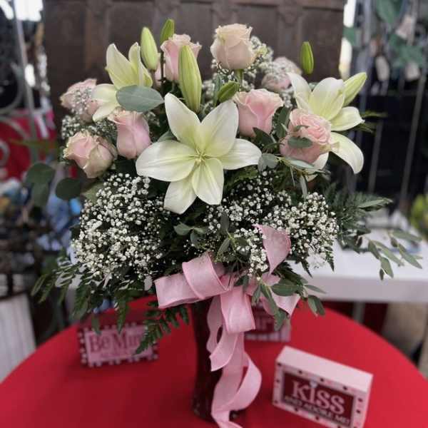 Bouquet of pink roses and white lilies with a pink ribbon