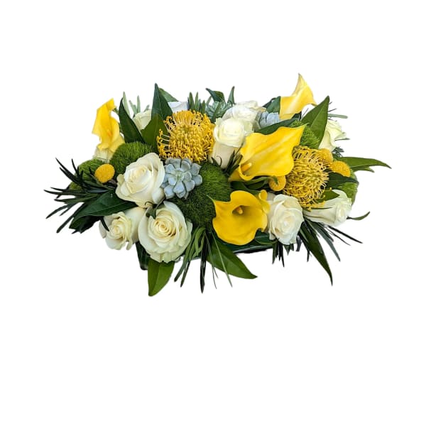 Yellow calla lilies and white roses in a low bouquet