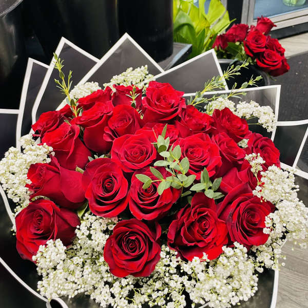 Bouquet of red roses with white baby's breath in black wrapping