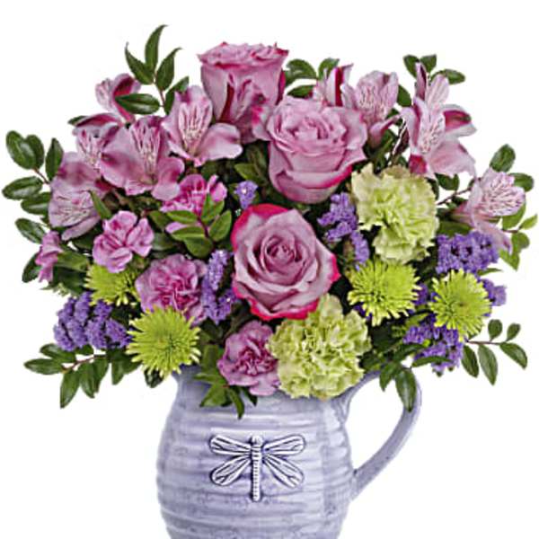 Pink roses and alstroemeria in a lavender ceramic pitcher vase