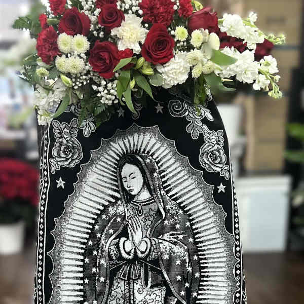 Red and white floral arrangement on a black memorial cloth