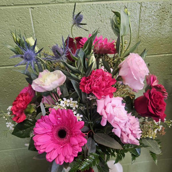 Mixed bouquet of pink and red flowers in a red vase