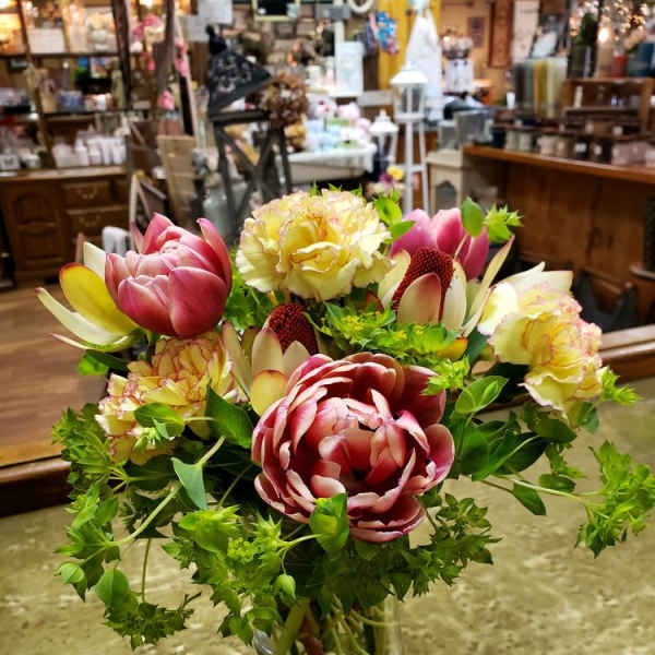 Mixed bouquet of pink and cream flowers in a clear glass vase