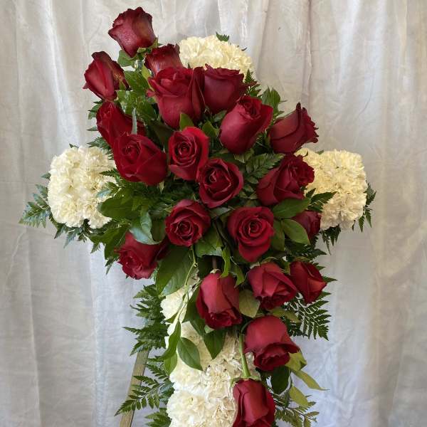 Cross-shaped floral tribute with red roses and white carnations