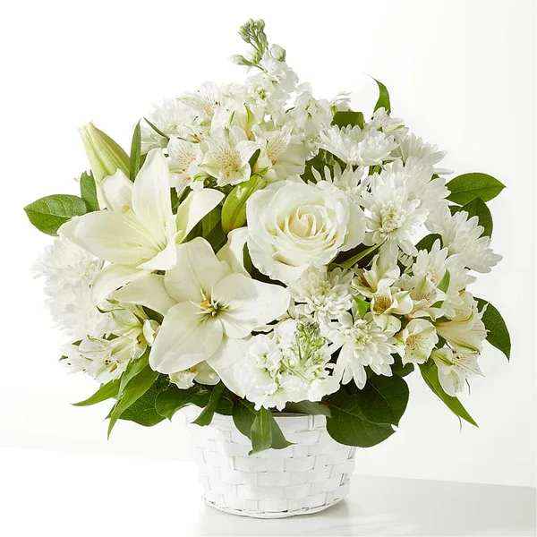 White floral arrangement in a white woven basket