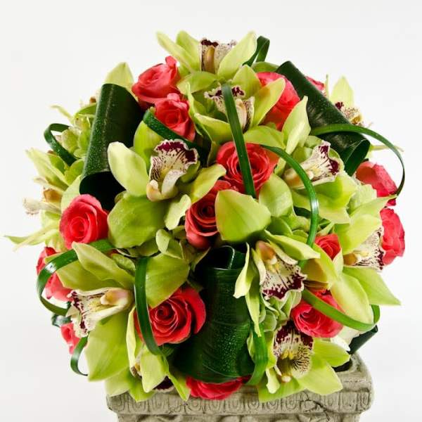 Bouquet of red roses and green orchids with dark ribbon loops