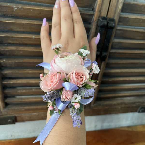 Pink rose wrist corsage with lavender ribbon and small purple flowers