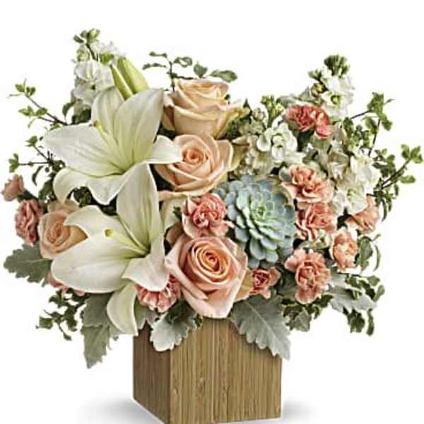 Bouquet of cream lilies, peach roses, and carnations in a wooden vase