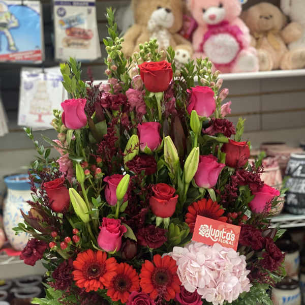 Mixed bouquet of red and pink roses with gerbera daisies in a wooden box