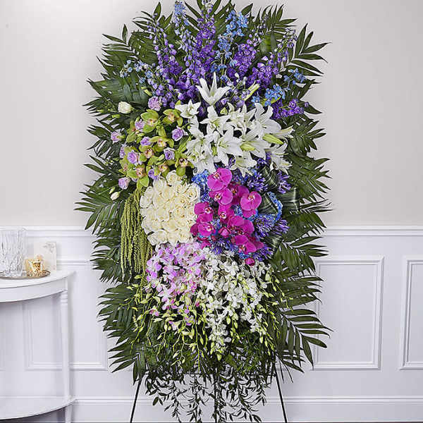 Tall standing floral spray with white lilies, orchids, and purple flowers