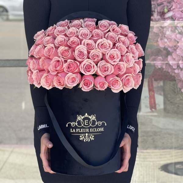 Large box of pink roses held by a person