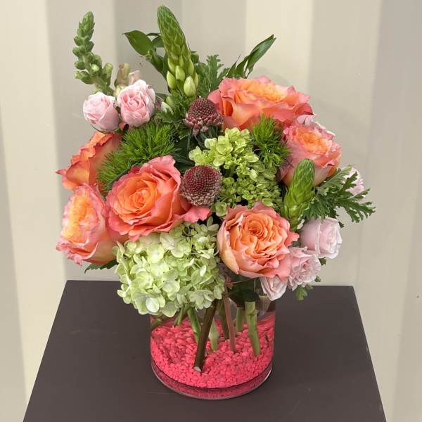 Bouquet of coral and pink roses in a clear glass vase