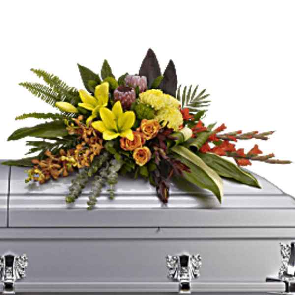 Bright mixed floral spray on a white casket