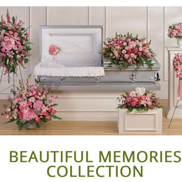 Pink floral funeral casket spray with matching standing wreaths and vase arrangements