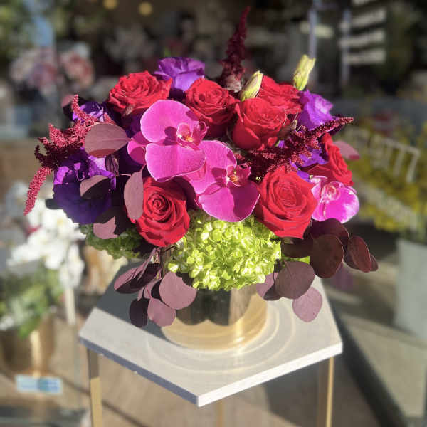 Bouquet of red roses and pink orchids in a glass vase