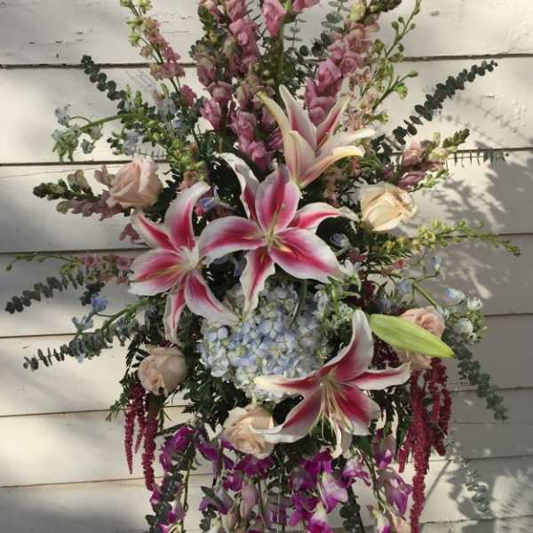 Tall floral spray with pink lilies, roses, and purple blooms