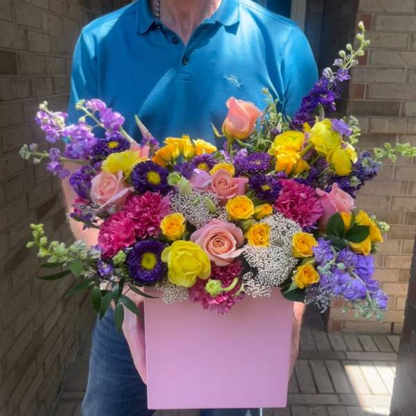 Mixed bouquet in a pink box with roses and purple blooms