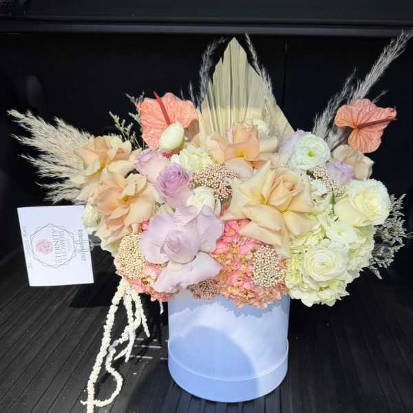 Pastel floral arrangement in a light blue box with pampas grass