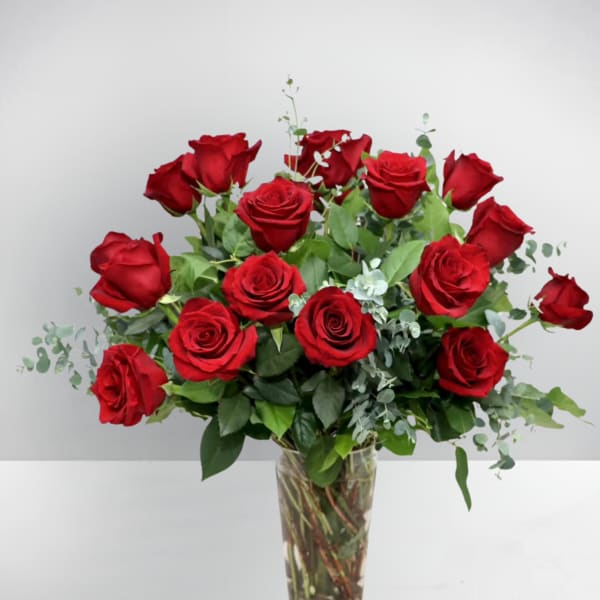 Red roses arranged in a clear glass vase