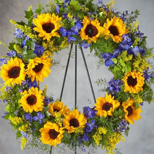 Sunflower wreath with blue flowers on a metal stand