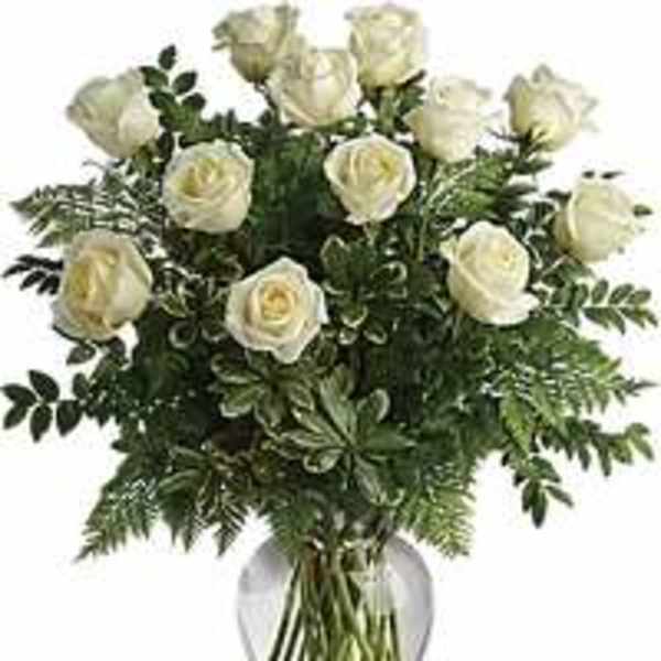 White roses arranged in a clear glass vase