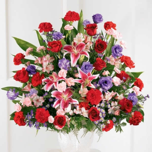 Large mixed bouquet in a white vase with red, pink, and purple flowers