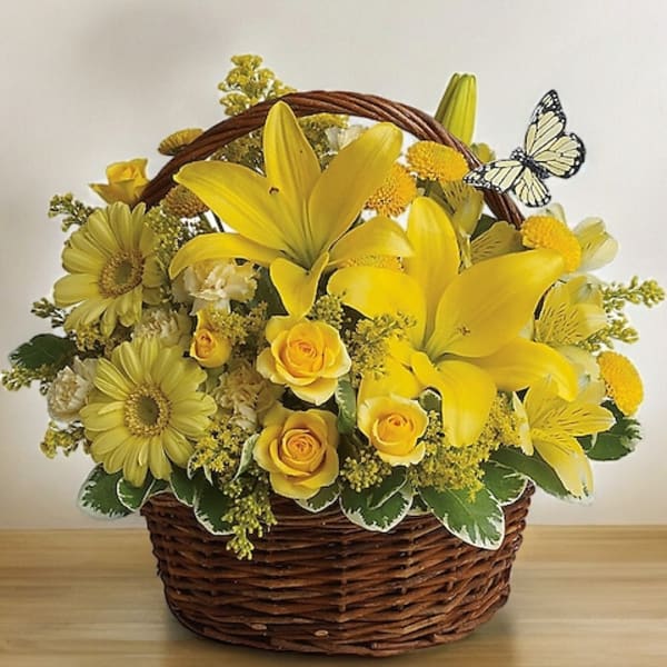 Yellow flowers arranged in a wicker basket with a butterfly decoration