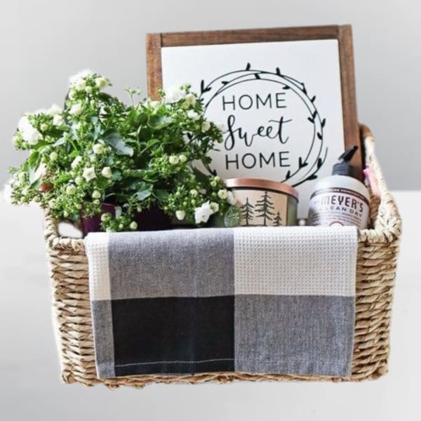 Gift basket with white flowers, a home sign, candle, and soap