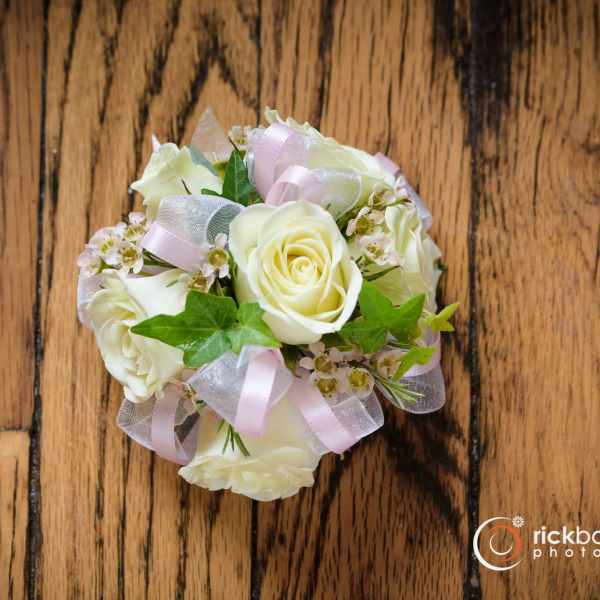 Small bouquet of white roses with pink ribbon accents