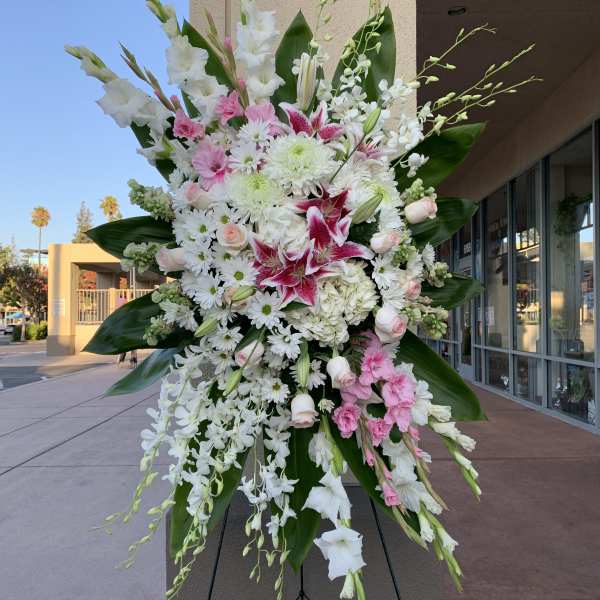 Large standing floral spray with white and pink flowers on an easel