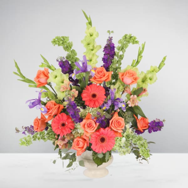 Colorful mixed bouquet in a white vase with roses and gerbera daisies