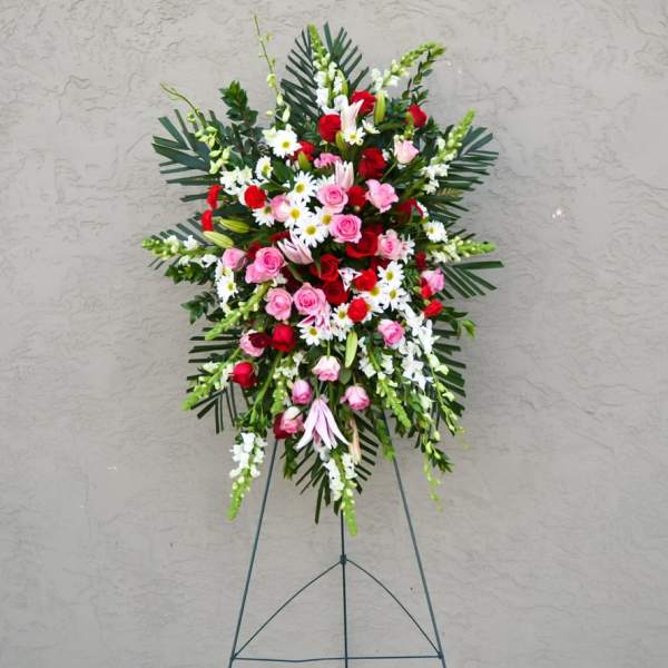 Standing floral spray with red and pink roses and white daisies